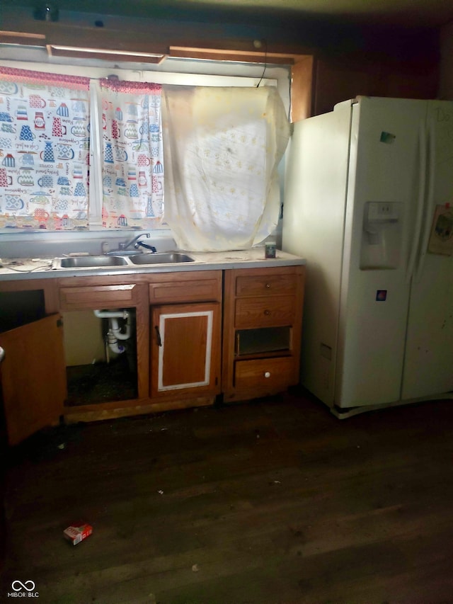 kitchen featuring dark hardwood / wood-style flooring, sink, and white refrigerator with ice dispenser