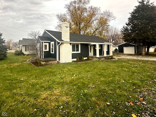 view of front of property featuring an outbuilding, a front yard, and a garage