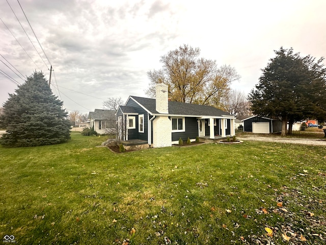 view of front of home with an outbuilding, a front yard, and a garage