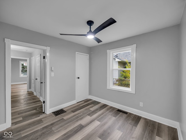 unfurnished bedroom featuring wood-type flooring, a closet, and ceiling fan