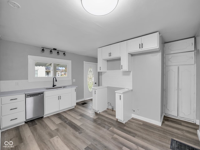 kitchen featuring white cabinets, light hardwood / wood-style floors, stainless steel dishwasher, and sink