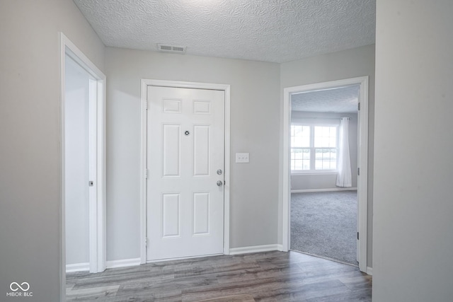 foyer featuring light hardwood / wood-style floors and a textured ceiling