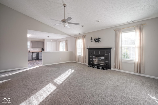 unfurnished living room featuring a textured ceiling, a wealth of natural light, and lofted ceiling