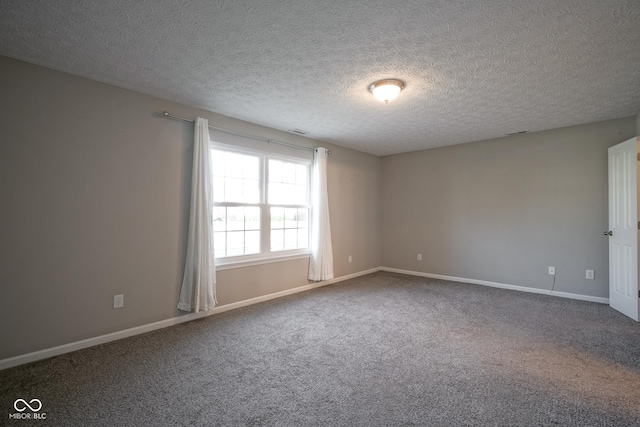 unfurnished room featuring carpet and a textured ceiling