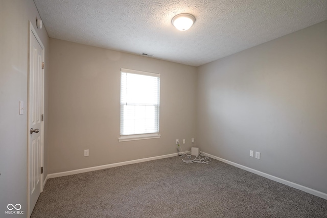 carpeted empty room with a textured ceiling