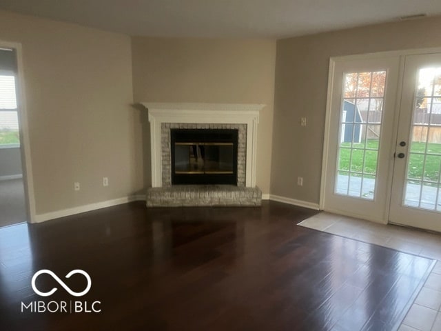 unfurnished living room featuring a fireplace and hardwood / wood-style flooring