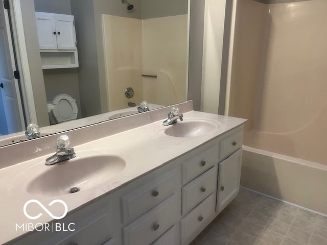 full bathroom featuring toilet, vanity, and shower / washtub combination