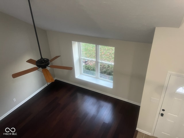 unfurnished room featuring dark wood-type flooring and ceiling fan