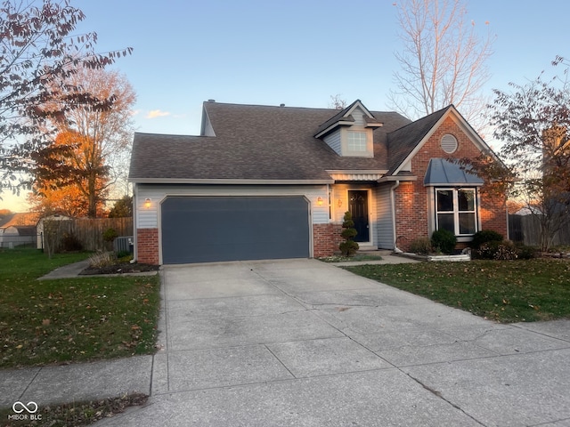 view of front property featuring a garage, central AC unit, and a yard