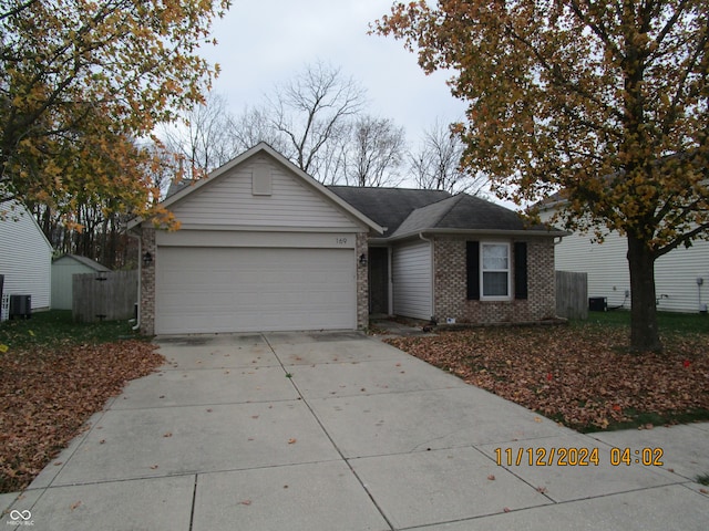 single story home with central air condition unit and a garage