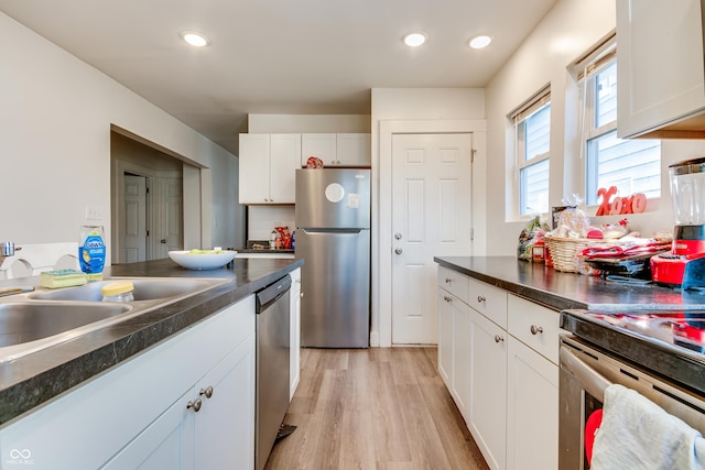 951 W 33rd St, Indianapolis, IN 46208 - kitchen with appliances with stainless steel finishes, dark countertops, white cabinetry, light wood-type flooring, and recessed lighting