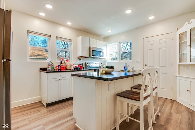 kitchen with white cabinets, plenty of natural light, and stainless steel appliances