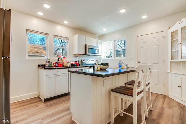 951 W 33rd St, Indianapolis, IN 46208 - kitchen with stainless steel appliances, dark countertops, light wood finished floors, plenty of natural light, and recessed lighting