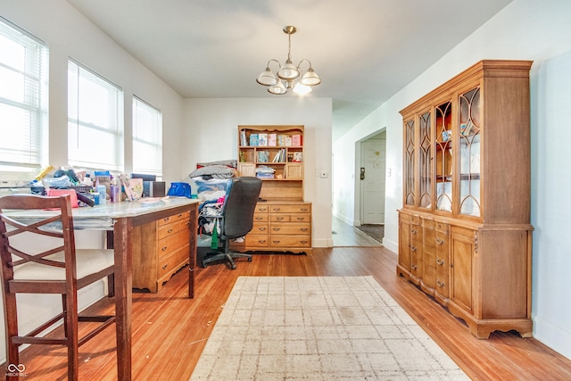 office space featuring light hardwood / wood-style floors, an inviting chandelier, and plenty of natural light