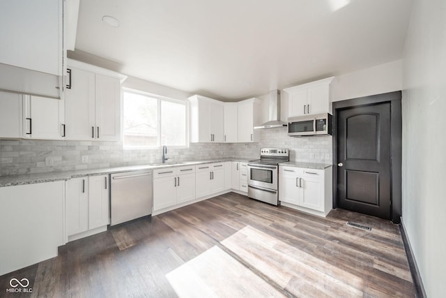 425 Sanders St, Indianapolis, IN 46225 - kitchen with stainless steel appliances, wall chimney range hood, a sink, and backsplash