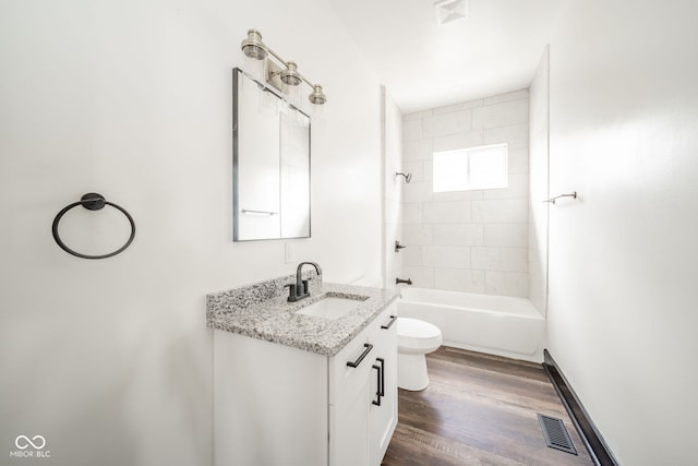 full bathroom featuring toilet, tiled shower / bath combo, vanity, and hardwood / wood-style floors