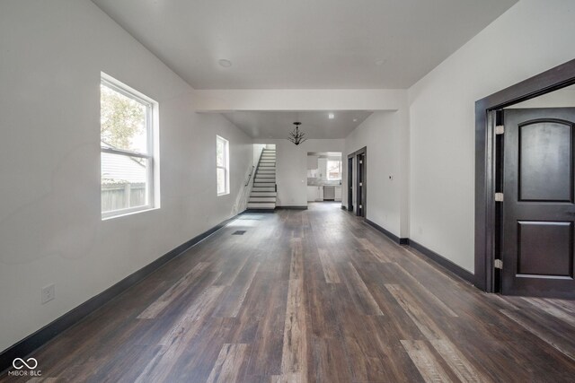 425 Sanders St, Indianapolis, IN 46225 - unfurnished living room with stairway, dark wood-style floors, baseboards, and a chandelier