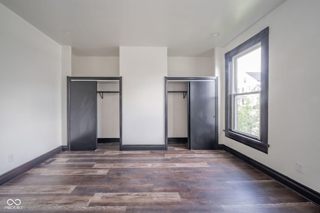 425 Sanders St, Indianapolis, IN 46225 - unfurnished bedroom with wood finished floors, baseboards, and multiple closets