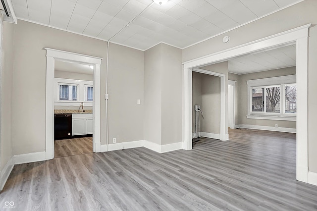 unfurnished room featuring crown molding, sink, and light hardwood / wood-style flooring