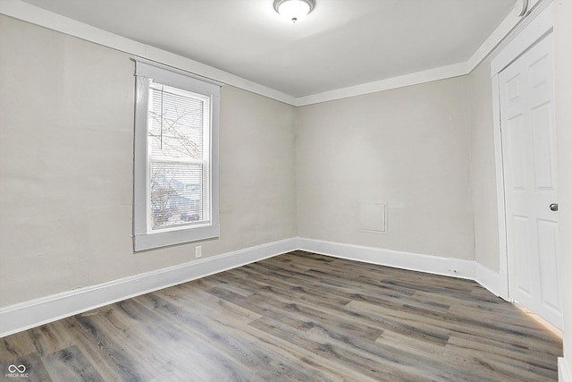 empty room featuring crown molding and dark wood-type flooring