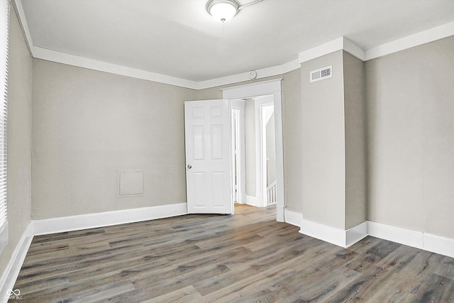 unfurnished room featuring ornamental molding and dark hardwood / wood-style floors