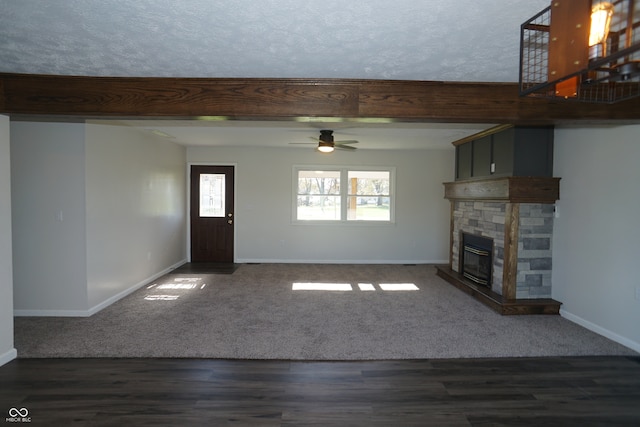 unfurnished living room with a fireplace, dark hardwood / wood-style floors, plenty of natural light, and ceiling fan