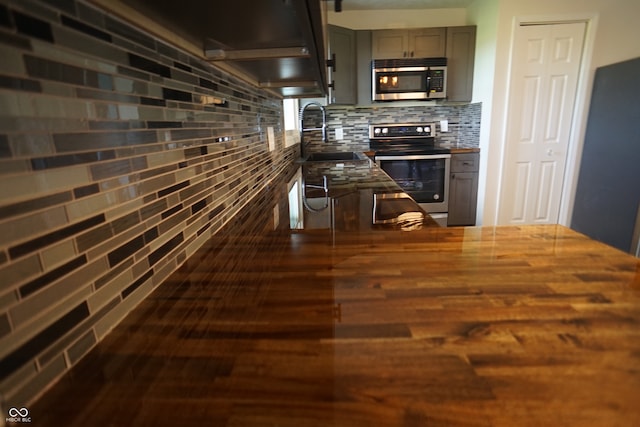 kitchen with sink, appliances with stainless steel finishes, tasteful backsplash, gray cabinetry, and dark hardwood / wood-style flooring