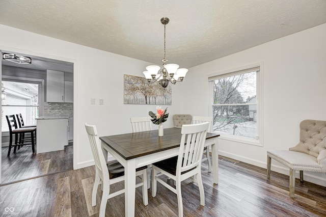 5909 Buttonwood Dr, Noblesville, IN 46062 - dining space with dark wood finished floors, a chandelier, baseboards, and a textured ceiling