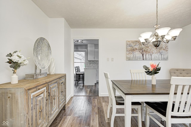 5909 Buttonwood Dr, Noblesville, IN 46062 - dining space with a chandelier, dark wood-style floors, a textured ceiling, and baseboards