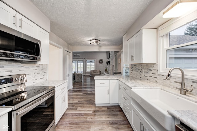 5909 Buttonwood Dr, Noblesville, IN 46062 - kitchen with appliances with stainless steel finishes, a sink, wood finished floors, white cabinets, and a textured ceiling