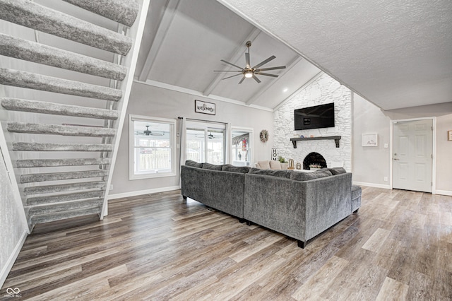 5909 Buttonwood Dr, Noblesville, IN 46062 - living area with ceiling fan, wood finished floors, a stone fireplace, baseboards, and a textured ceiling