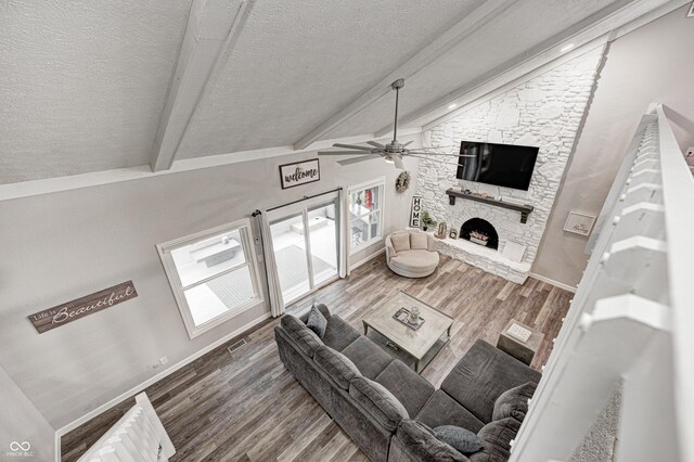 5909 Buttonwood Dr, Noblesville, IN 46062 - living area featuring wood finished floors, a stone fireplace, a textured ceiling, ceiling fan, and baseboards