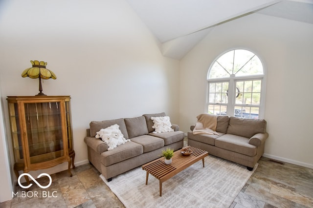 living area with lofted ceiling, visible vents, and baseboards