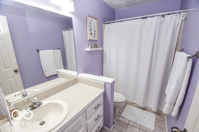 bathroom featuring toilet, a textured ceiling, tile patterned flooring, and vanity