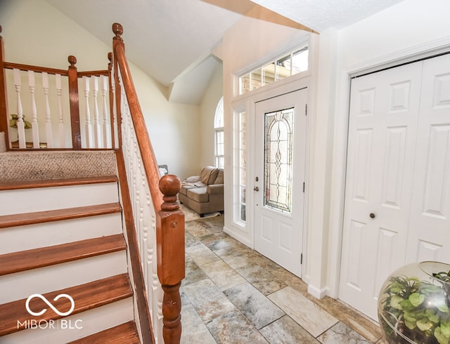 foyer with lofted ceiling and stairway