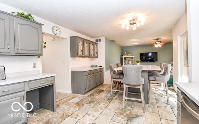 kitchen featuring visible vents, open floor plan, a kitchen breakfast bar, gray cabinets, and light countertops