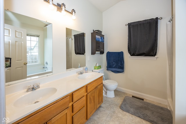 bathroom featuring a bathing tub, tile patterned flooring, vanity, and toilet