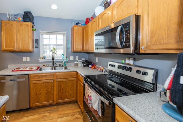 kitchen featuring appliances with stainless steel finishes, light hardwood / wood-style floors, and sink