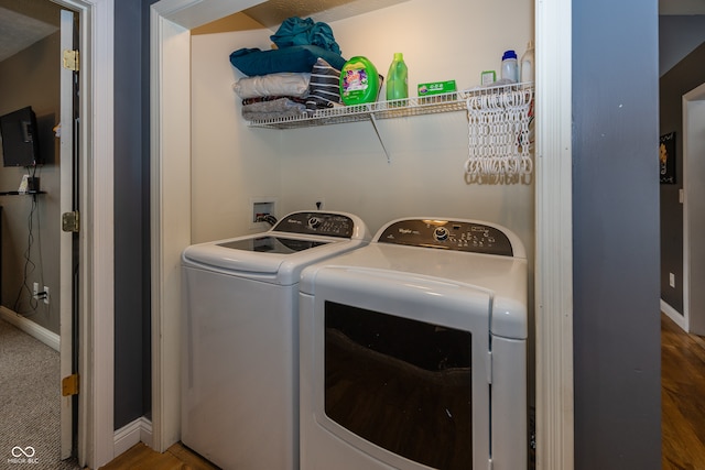 laundry room featuring wood-type flooring and separate washer and dryer