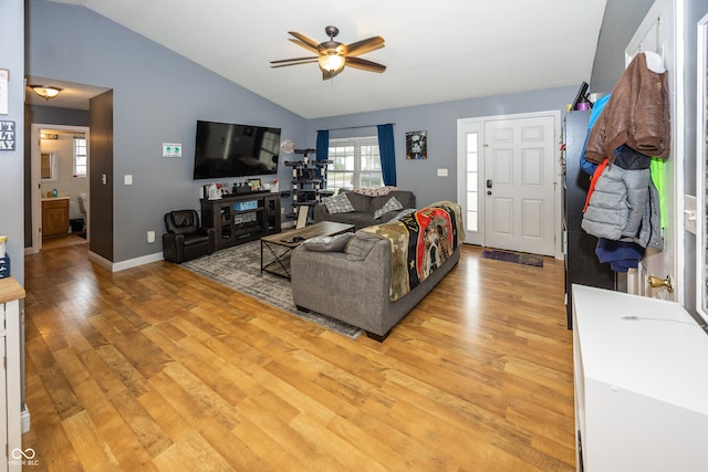 living room featuring ceiling fan, light hardwood / wood-style floors, and vaulted ceiling