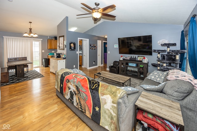 living room with light hardwood / wood-style flooring, ceiling fan with notable chandelier, and lofted ceiling