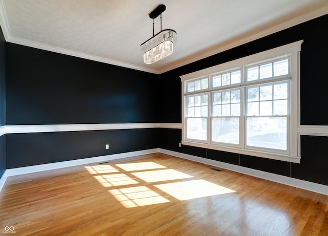 7290 Lockford Walk N, Avon, IN 46123 - empty room featuring a chandelier, light wood finished floors, ornamental molding, and baseboards