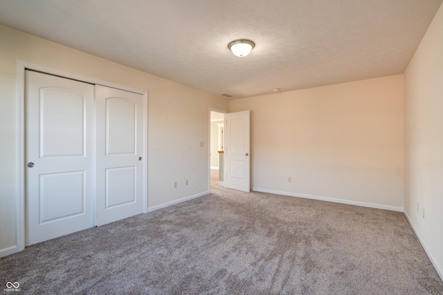7290 Lockford Walk N, Avon, IN 46123 - unfurnished bedroom featuring carpet, a closet, baseboards, and a textured ceiling
