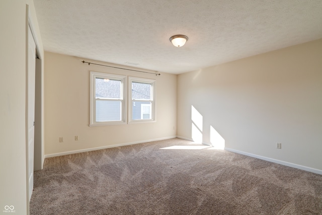 carpeted spare room with a textured ceiling