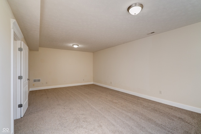 empty room featuring carpet and a textured ceiling