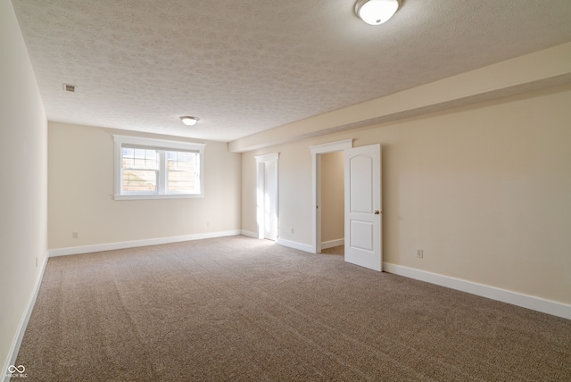 unfurnished room with a textured ceiling and carpet floors