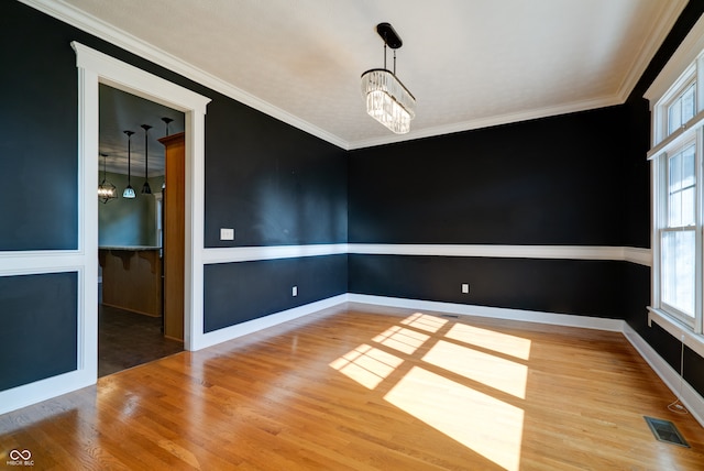 unfurnished dining area with a chandelier, hardwood / wood-style flooring, and crown molding