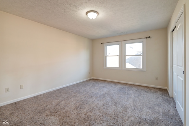 carpeted spare room with a textured ceiling