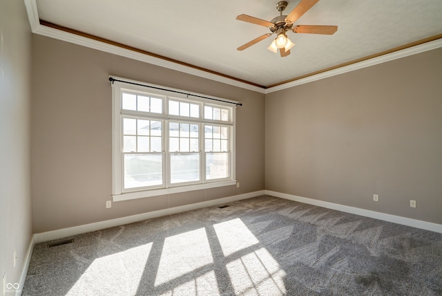 carpeted spare room with ceiling fan and crown molding