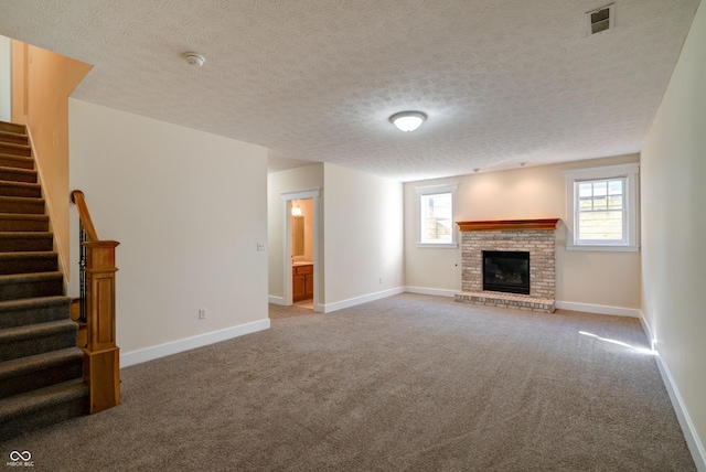 7290 Lockford Walk N, Avon, IN 46123 - unfurnished living room with carpet, stairway, a fireplace, baseboards, and a textured ceiling